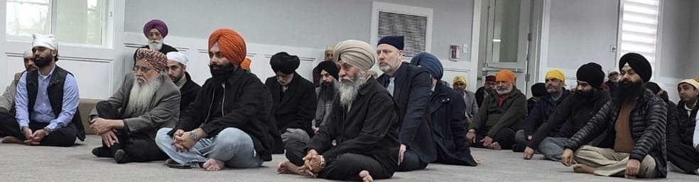 Attendees seated on the floor during a community gathering.
