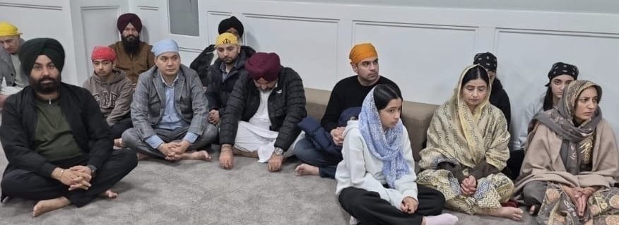 Women and men sit together on the floor during the gathering.