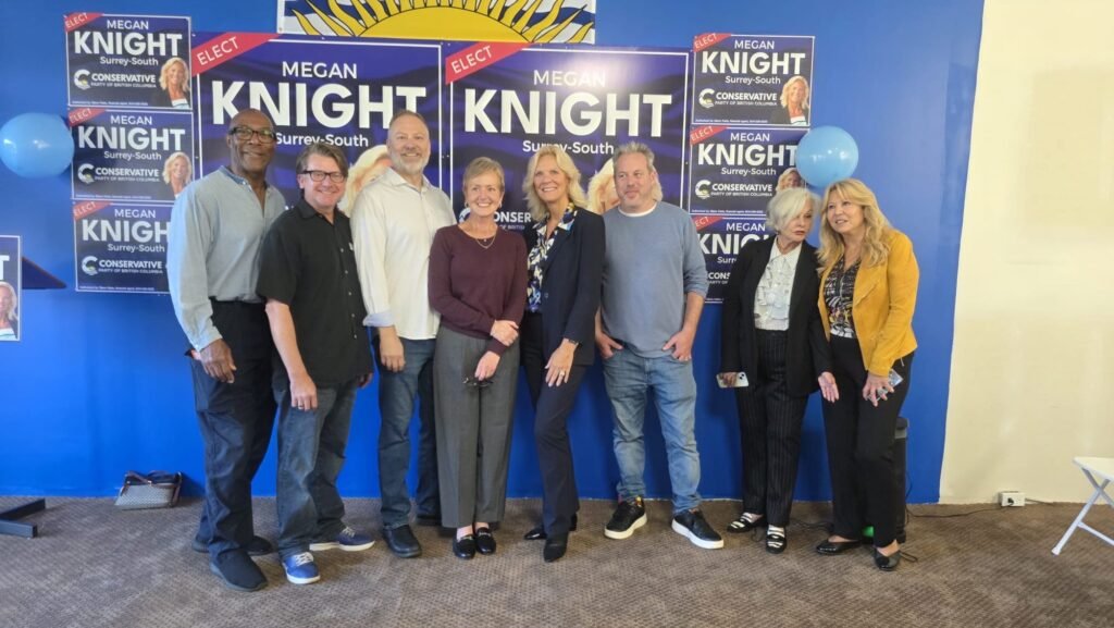 Megan Knight Campaign Launch Draws Strong Local Support in Surrey 5 A group of attendees poses beneath Megan Knight campaign posters at the Surrey launch.