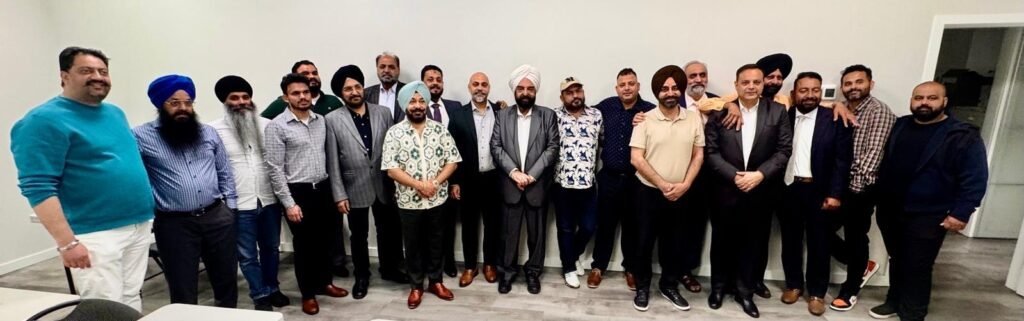 A group of local election candidates pose for a photograph at an indoor campaign meeting.